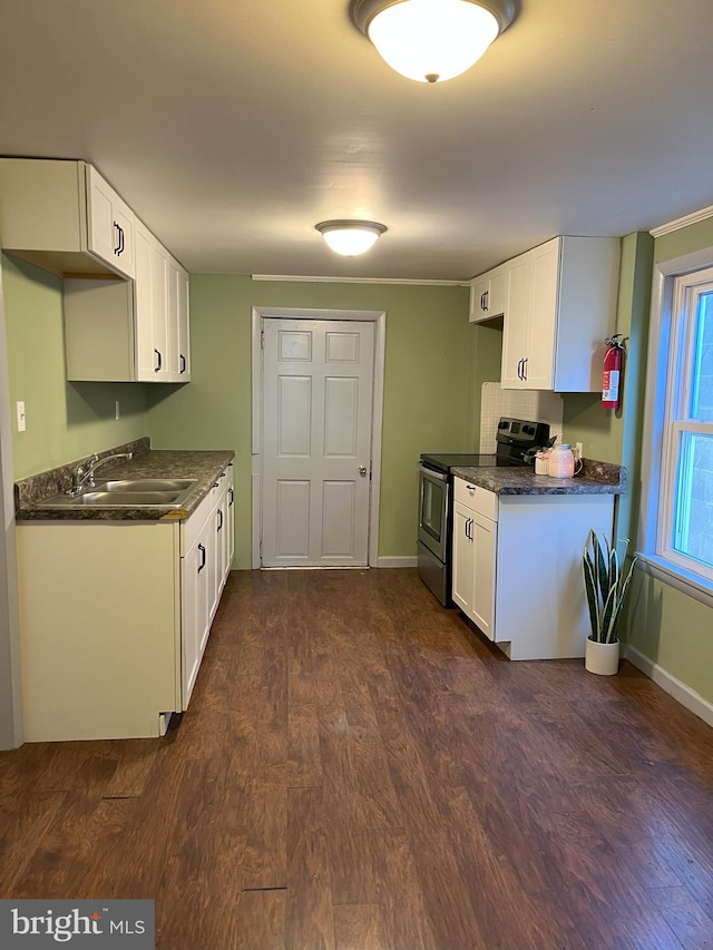 kitchen with dark wood-style flooring, a sink, stainless steel range with electric cooktop, white cabinets, and dark countertops