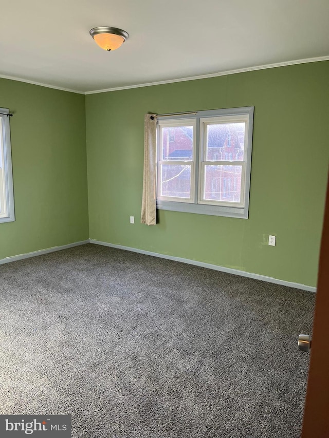 carpeted empty room featuring baseboards and ornamental molding