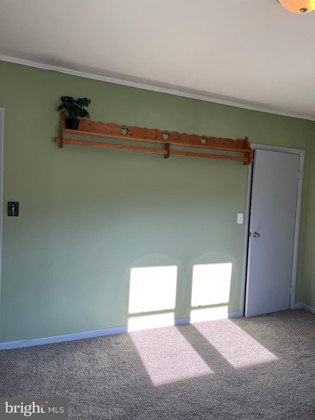 empty room with baseboards, carpet floors, and ornamental molding