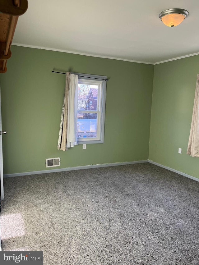 empty room with visible vents, baseboards, ornamental molding, and carpet flooring