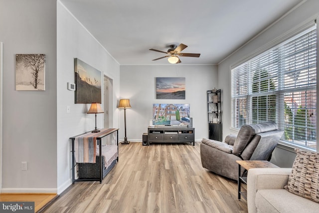 living room with a healthy amount of sunlight, wood finished floors, and crown molding