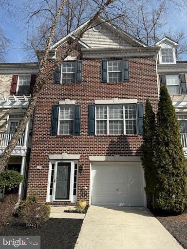 view of front of home featuring a garage, brick siding, and driveway