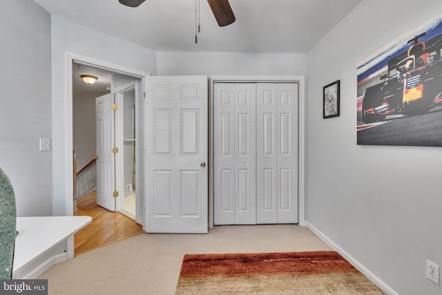 bedroom featuring a ceiling fan, carpet, a closet, and baseboards