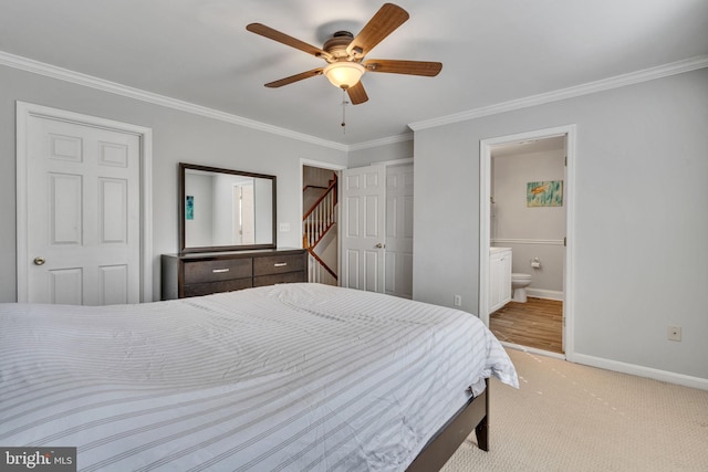 bedroom with ornamental molding, a ceiling fan, ensuite bath, carpet floors, and baseboards