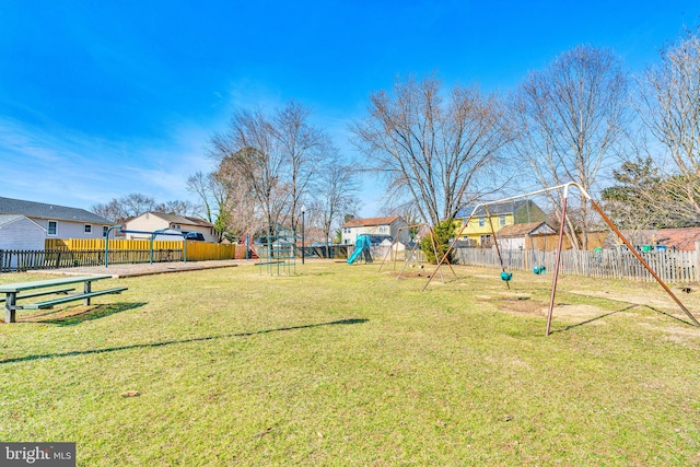 view of yard featuring a fenced backyard, playground community, and a residential view