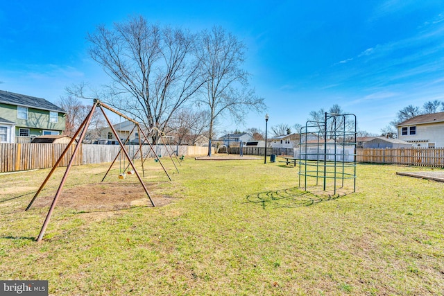 view of yard with a residential view, a playground, and a fenced backyard