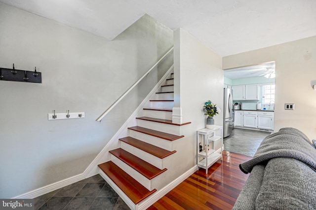 stairs with wood finished floors and baseboards