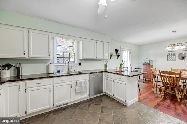 kitchen featuring a sink, white cabinets, a peninsula, and stainless steel dishwasher