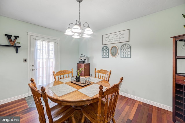 dining space featuring a notable chandelier, baseboards, and dark wood-type flooring