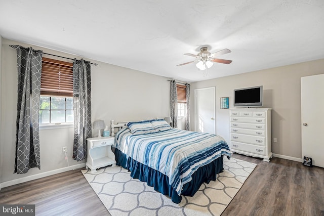 bedroom featuring a ceiling fan, baseboards, and wood finished floors