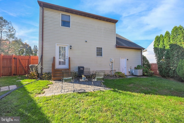 back of house featuring central air condition unit, a lawn, entry steps, a patio, and a fenced backyard