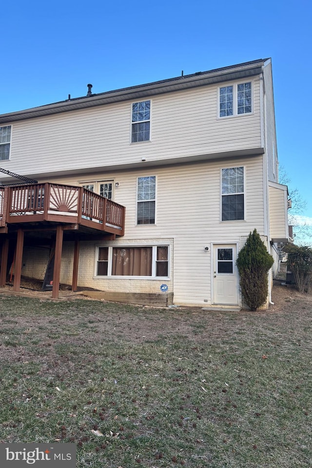 back of property featuring a yard and a wooden deck