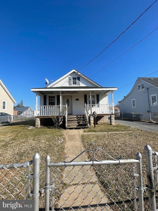 view of front facade featuring a fenced front yard, covered porch, and a gate