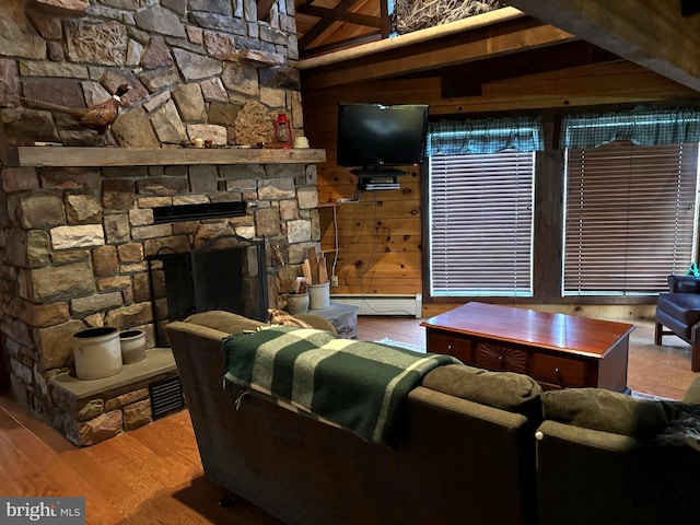 living area with a baseboard radiator, wooden walls, wood finished floors, and a fireplace