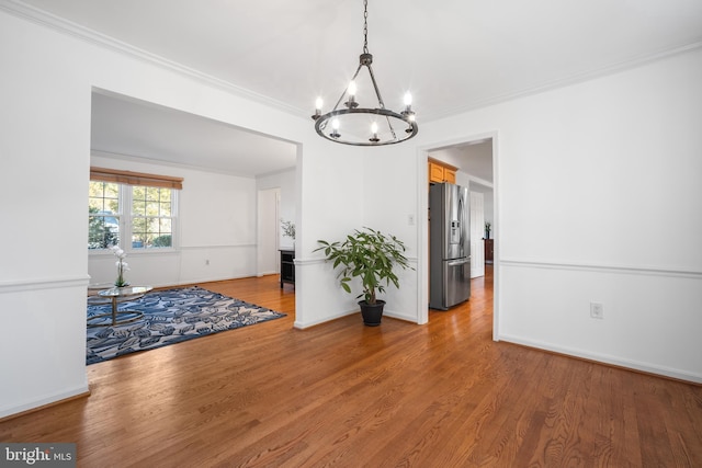 dining area featuring wood finished floors, baseboards, and ornamental molding