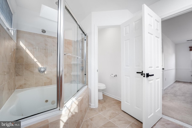 bathroom featuring baseboards, enclosed tub / shower combo, toilet, and tile patterned flooring