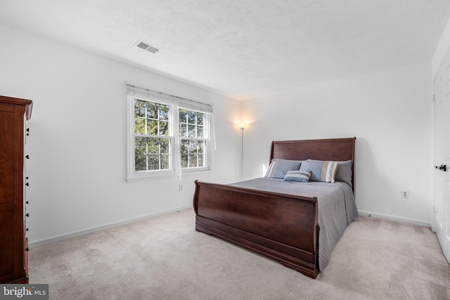 bedroom featuring baseboards, visible vents, carpet floors, and a textured ceiling