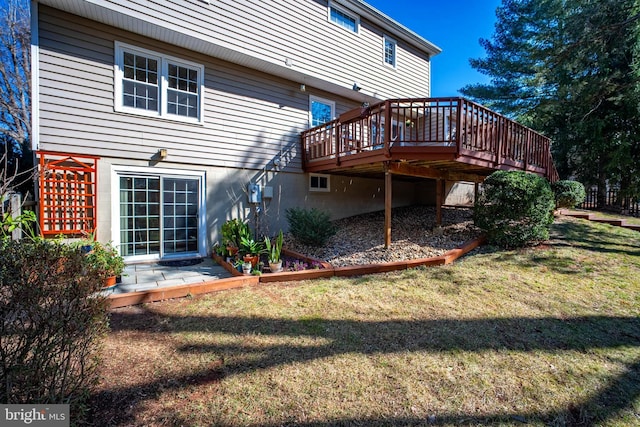 rear view of house with a wooden deck and a yard