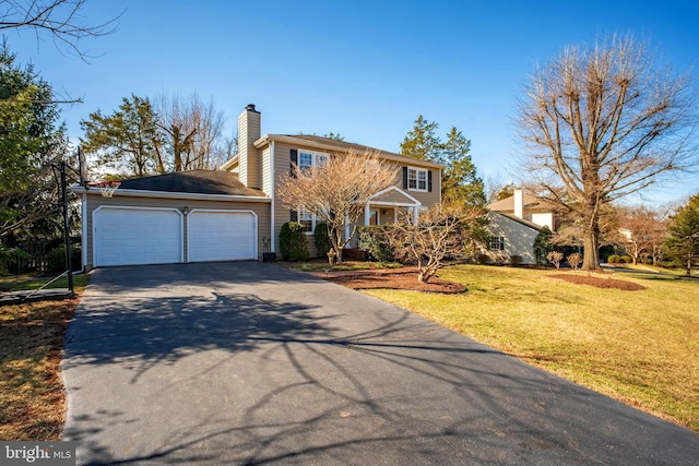 view of front of home with a garage, a front yard, a chimney, and driveway