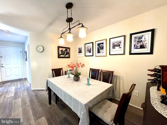 dining space with baseboards and dark wood-style flooring