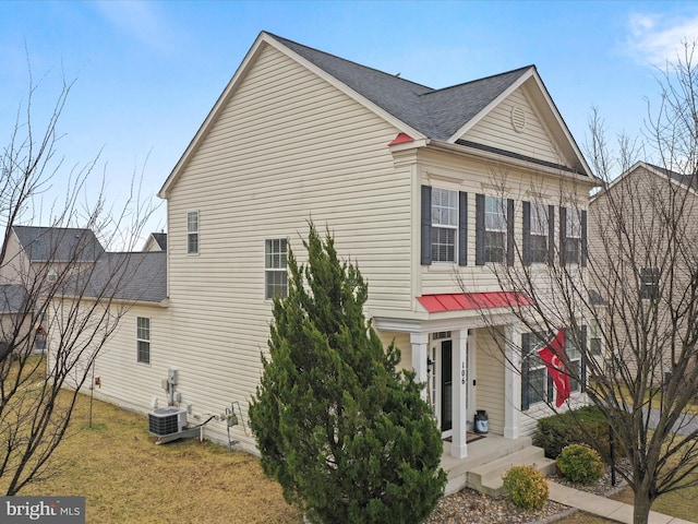 view of side of property featuring cooling unit, a yard, and roof with shingles