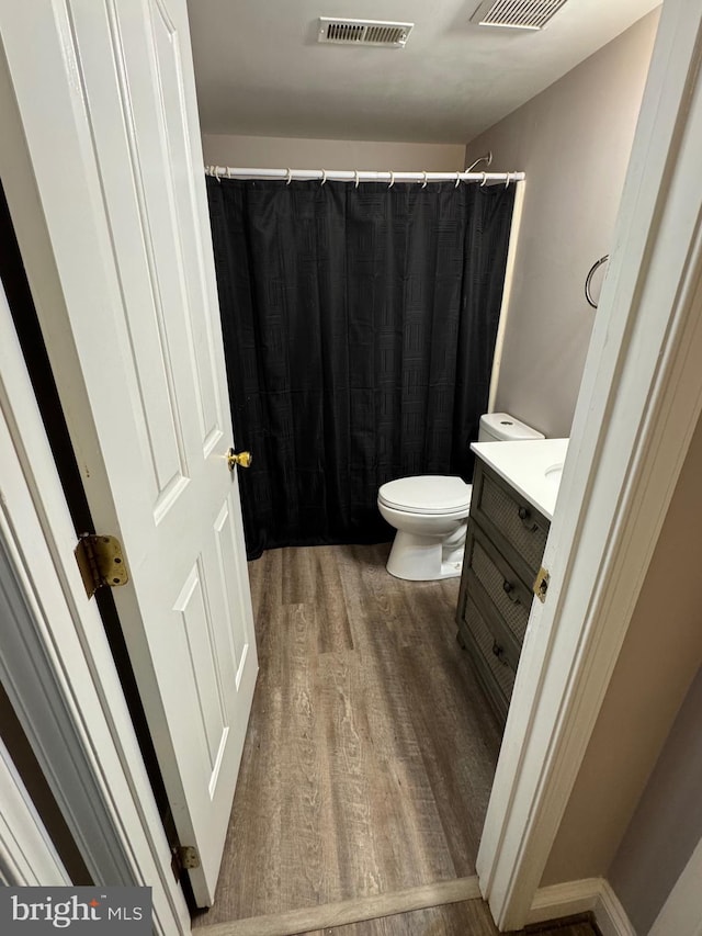 full bath with visible vents, toilet, wood finished floors, and vanity