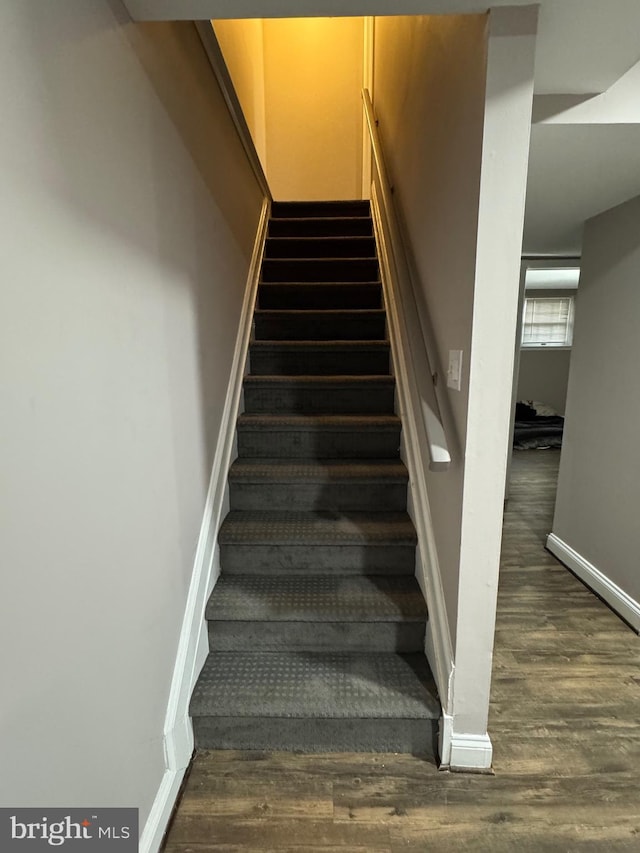 stairs featuring baseboards and wood finished floors