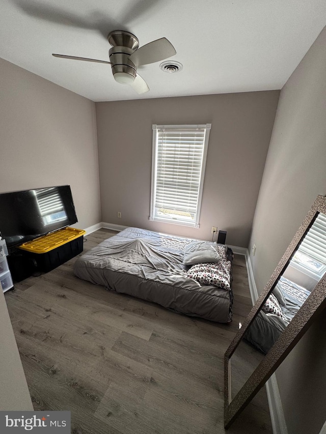 bedroom with visible vents, ceiling fan, baseboards, and wood finished floors