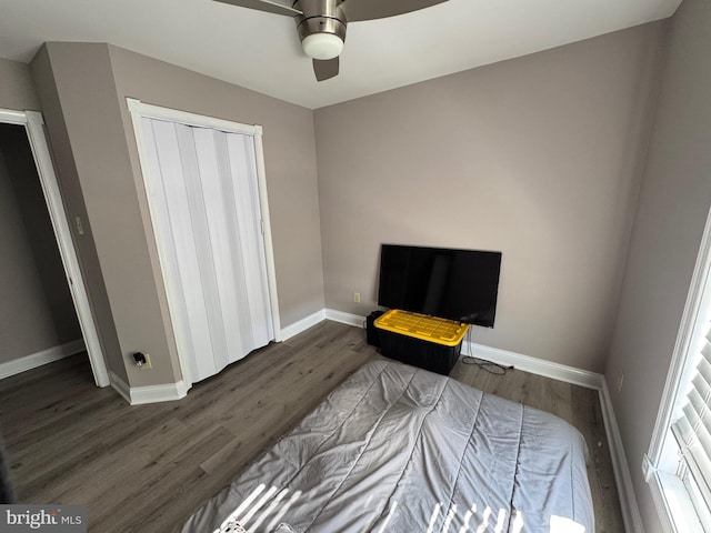 bedroom featuring a closet, ceiling fan, baseboards, and wood finished floors