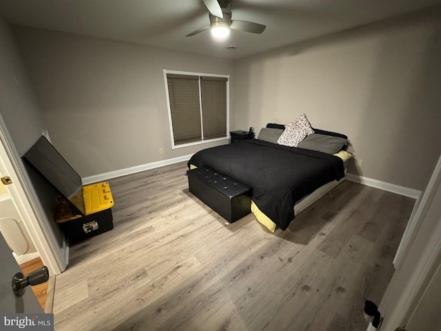 bedroom featuring ceiling fan, baseboards, and wood finished floors