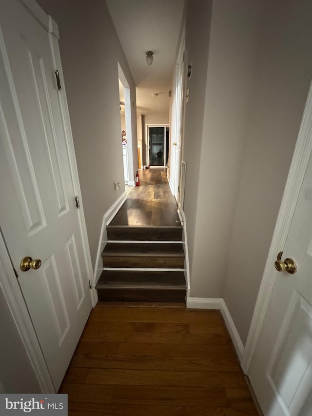 stairway with baseboards and wood finished floors