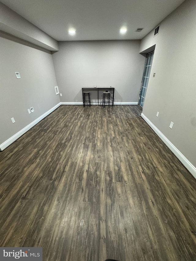 basement with visible vents, baseboards, and wood finished floors