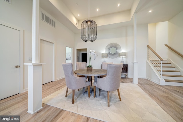 dining space featuring visible vents, wood finished floors, and stairs