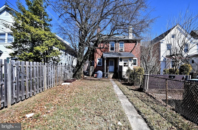 exterior space with brick siding, fence private yard, and a chimney