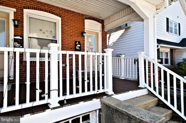 property entrance featuring brick siding and a porch