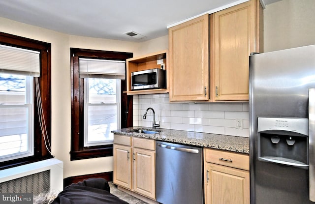 kitchen featuring a sink, stainless steel appliances, visible vents, and light brown cabinets