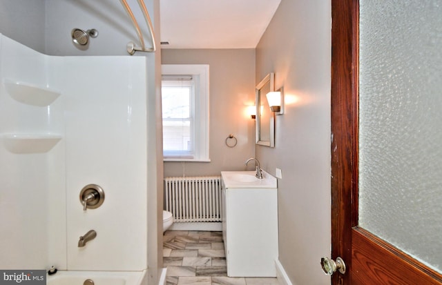 full bathroom featuring washtub / shower combination, radiator, vanity, and toilet