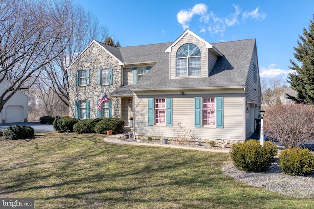 view of front facade with a front lawn and a shingled roof