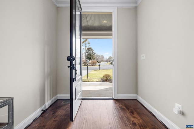 foyer featuring dark wood-type flooring, baseboards, and ornamental molding