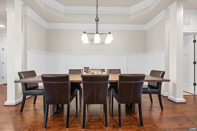 dining room with a tray ceiling, a decorative wall, and a notable chandelier