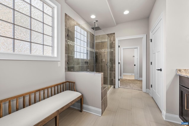 full bathroom with recessed lighting, baseboards, a stall shower, and vanity