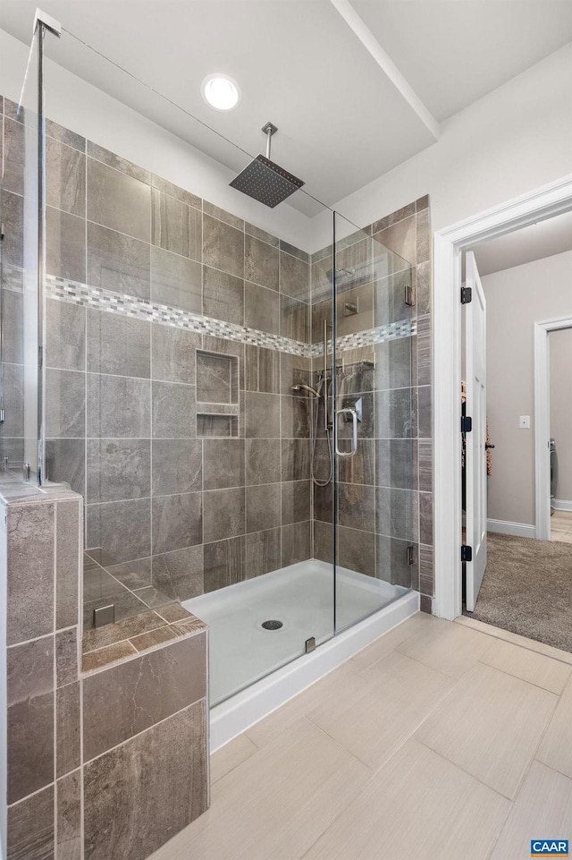 bathroom featuring baseboards and a shower stall