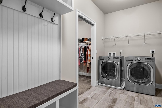 washroom with baseboards, independent washer and dryer, and laundry area