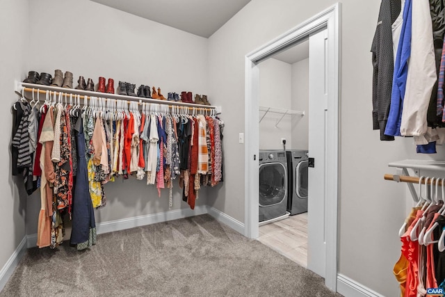 walk in closet featuring separate washer and dryer and carpet flooring