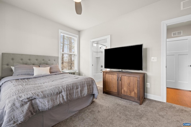 bedroom with baseboards, visible vents, ensuite bathroom, and light carpet