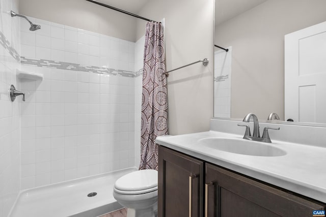 full bath with vanity, toilet, and a shower stall