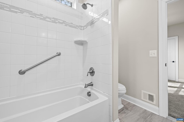 bathroom featuring visible vents, bathtub / shower combination, toilet, and baseboards