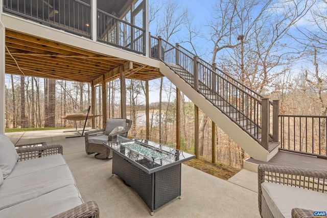 view of patio with an outdoor living space with a fire pit and stairs