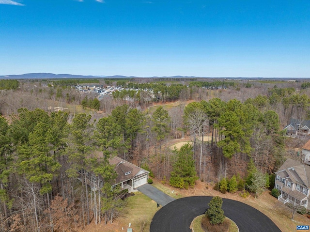 birds eye view of property featuring a mountain view and a wooded view