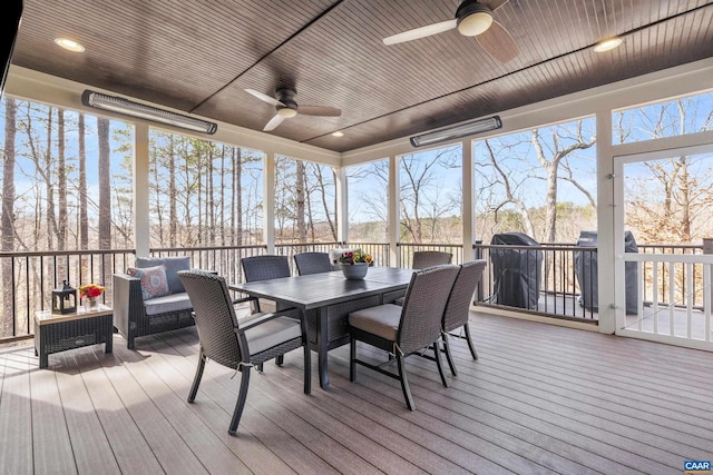 sunroom / solarium featuring plenty of natural light, wood ceiling, and a ceiling fan